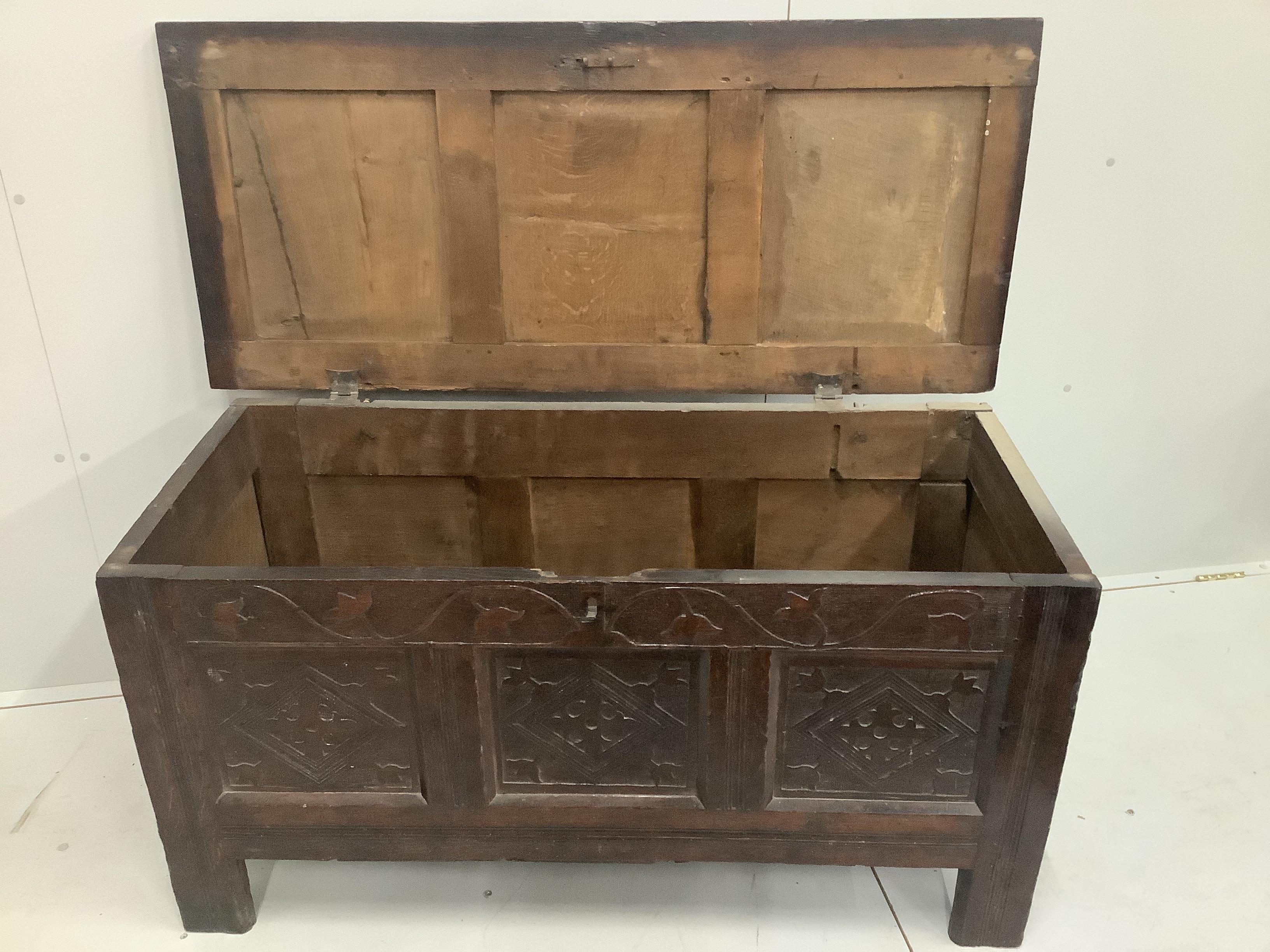 A 17th century and later panelled oak coffer with shallow carved foliate details, width 126cm